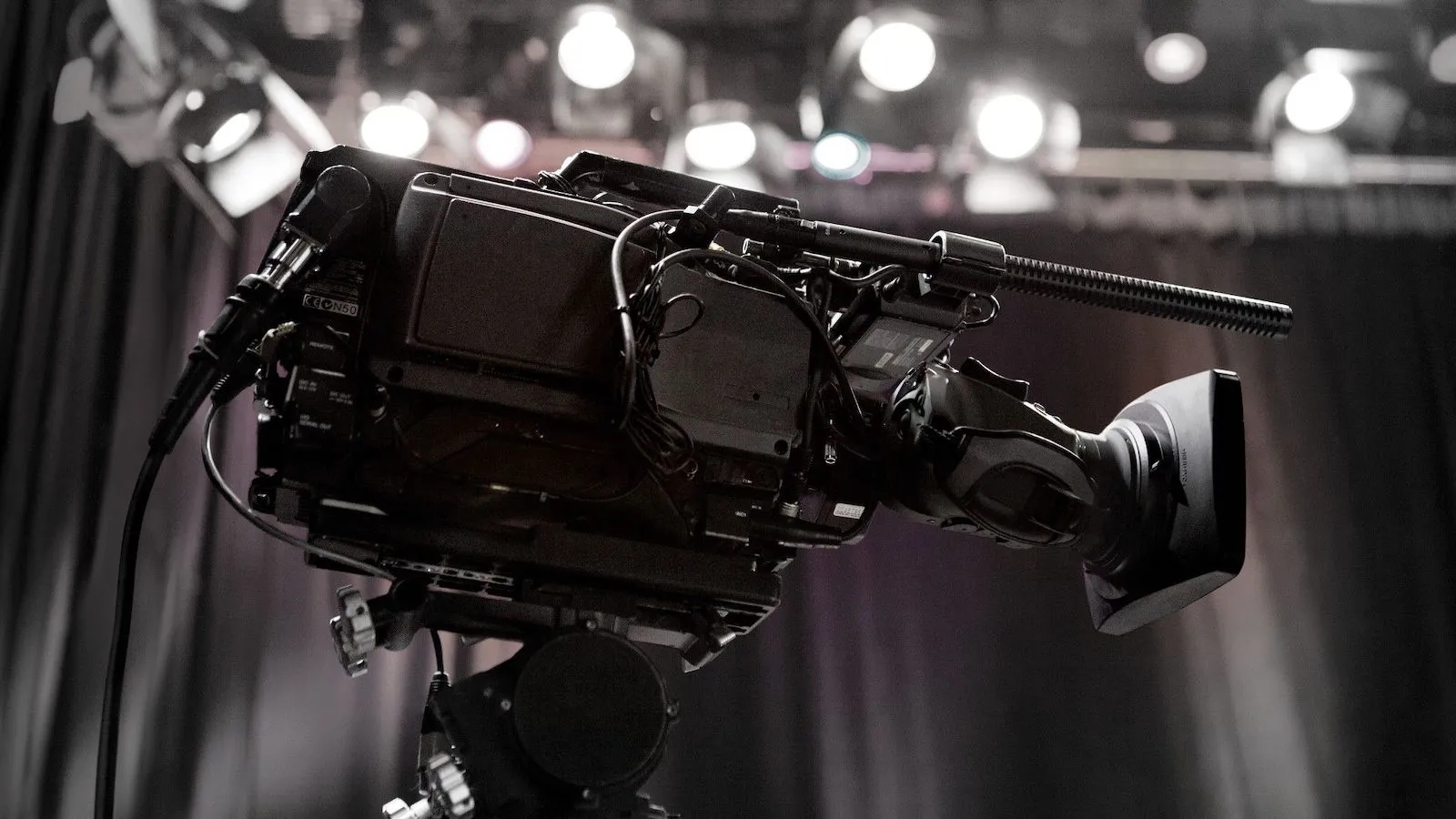 A camera with a shotgun mic on a TV stage.